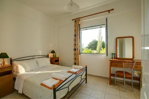 斯巴达利阿卡斯村公寓的一间卧室配有一张床、镜子和窗户