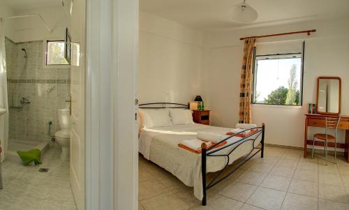 斯巴达利阿卡斯村公寓的一间卧室配有一张床,浴室设有淋浴。