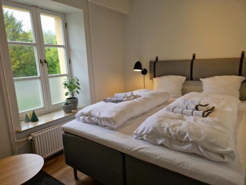 森讷堡Guesthouse的一间卧室设有两张带白色床单的床和窗户。