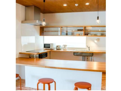 下关Pensione Shimado - Vacation STAY 37555v的厨房配有柜台和2张凳子