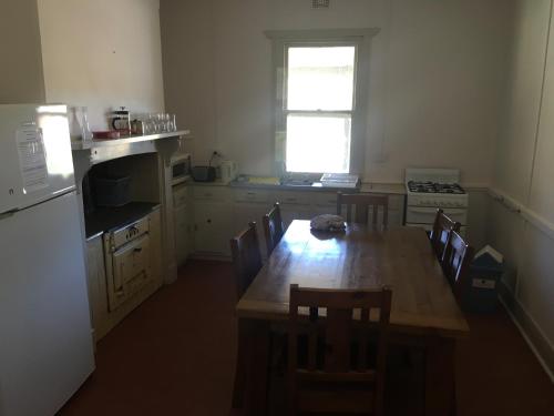 QuornOld Homestead - The Dutchmans Stern Conservation Park的厨房配有木桌、椅子和窗户