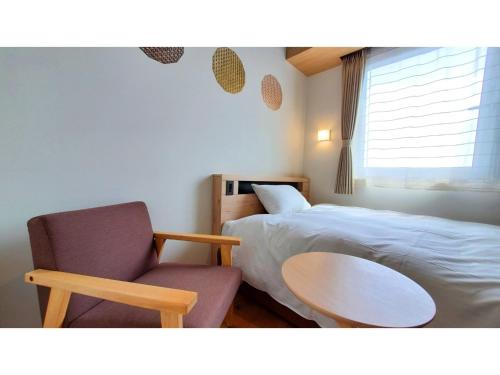Tochigiｂｕｓｉｎｅｓｓ&ａｃｔｉｖｉｔｙ ｃｈａｎｖｒｅ - Vacation STAY 64311v的一间卧室配有一张床、一把椅子和一张桌子