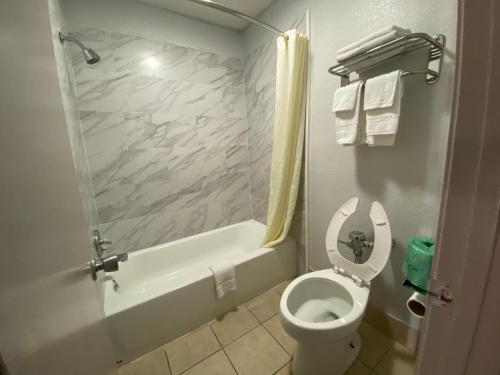琼斯伯勒Scottish inns Jonesboro的浴室配有卫生间、浴缸和水槽。