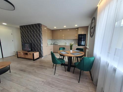 希奥利艾2-bedrooms apartment in city center Šiauliai的一间带桌子和绿色椅子的用餐室