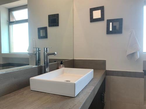 坎昆Cancún Airport Zone的浴室设有白色水槽和镜子