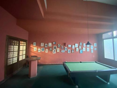 艾因苏赫纳Private chalte Palmera sokhna family的一间设有台球桌和一张带照片的墙壁的客房