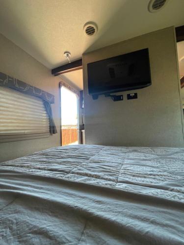 莫雷诺谷RV2 Stunning RV Private Netflix FreeParking的卧室配有一张床铺,墙上配有电视