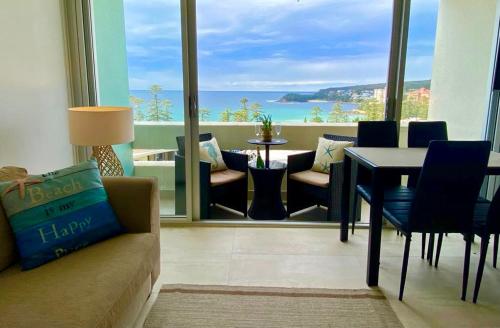 悉尼Manly Ocean Beach View Sunrise & Sunset的客厅配有沙发和桌子