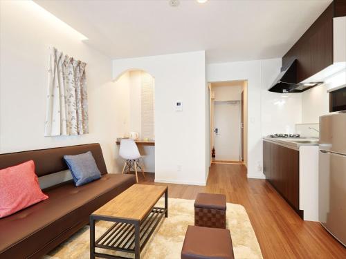 读谷村Condominium・yuyuki的带沙发的客厅和厨房