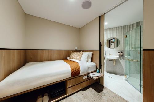 悉尼Aerotel Sydney (Arrivals B, International Terminal 1)的一间卧室配有一张床和淋浴
