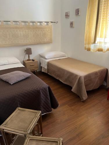 圣特雷莎加卢拉Da Adriana Guesthouse的一间卧室设有两张床,铺有木地板