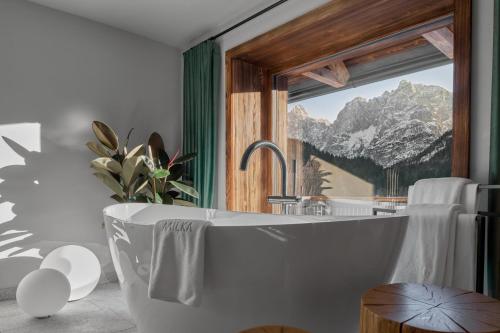 克拉尼斯卡戈拉Milka Boutique Hotel的带浴缸的浴室,享有山景
