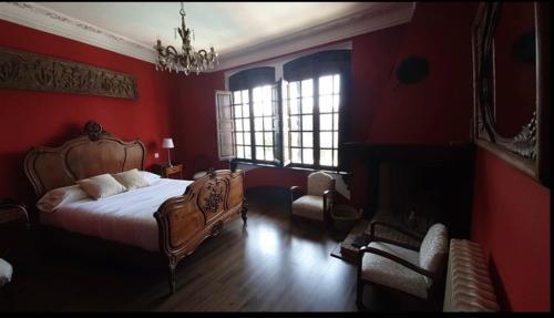 BrazatortasHotel Rural las Cinco Ranas的卧室设有红色的墙壁、一张床和椅子