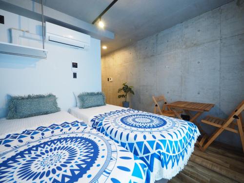 东京Luana Shibuya的两张带蓝色和白色床罩的床
