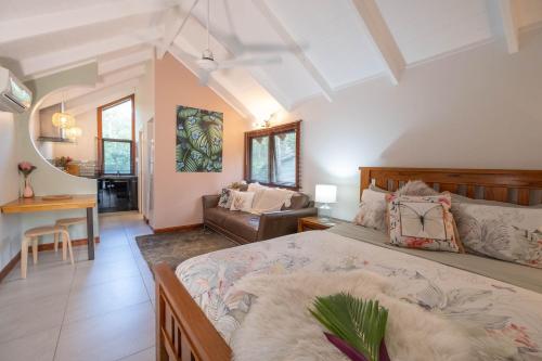 埃尔利海滩Airlie Beach Eco Cabins - Adults Only的一间卧室设有一张床和一间客厅。