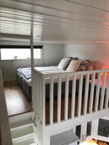 BrännöMycket trevlig stuga på Brännö med havsutsikt的一间卧室配有一张双层床和一张婴儿床。