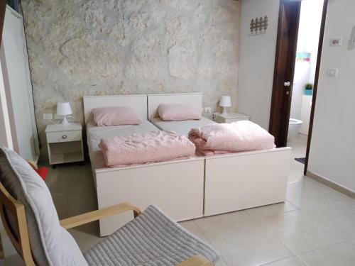 OvnatDead sea families unit的一间卧室配有两张带粉红色枕头的床