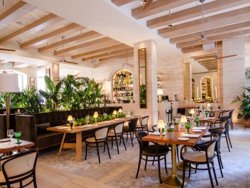 里斯本Browns Avenue Hotel的餐厅设有木桌和椅子,种有植物