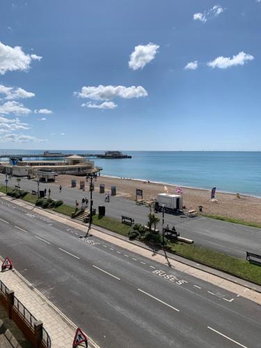 沃辛Stunning Beachfront Apartment, Perfect Sea View.的一条空的路,毗邻一个海边