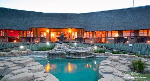 纳姆比提动物保护区The Springbok Lodge的一座房子前面设有游泳池