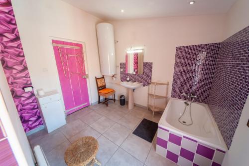 贝济耶Rêver à Béziers Centre ville et Gare的浴室设有紫色门、浴缸和水槽