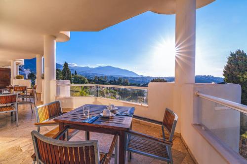 米哈斯Aparthotel Cordial Mijas Golf的美景阳台配有桌椅