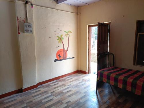 阿利鲍格Parvati Niwas Homestay -Nearby Revdanda Beach & Fort - WiFi available的一间设有一张床的客房,墙上挂着一棵棕榈树