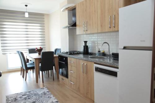 特拉布宗Kıvanç Residence的厨房配有木制橱柜和桌椅