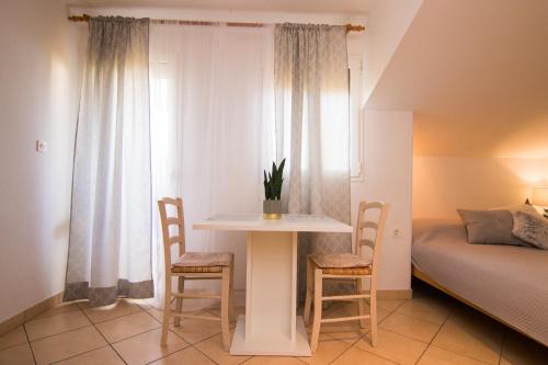 克尔克Apartments City Center Dekanić的配有桌子和两把椅子及一张床的房间