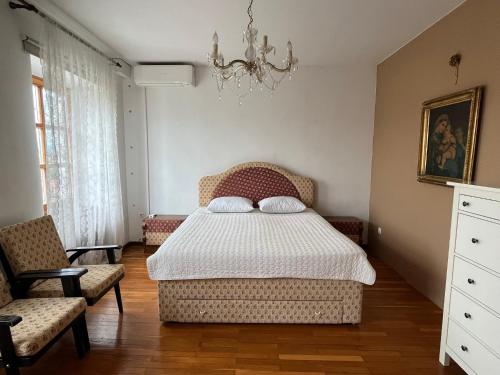 新梅斯托Hiša Kapitelj的一间卧室配有一张床、两把椅子和一个吊灯