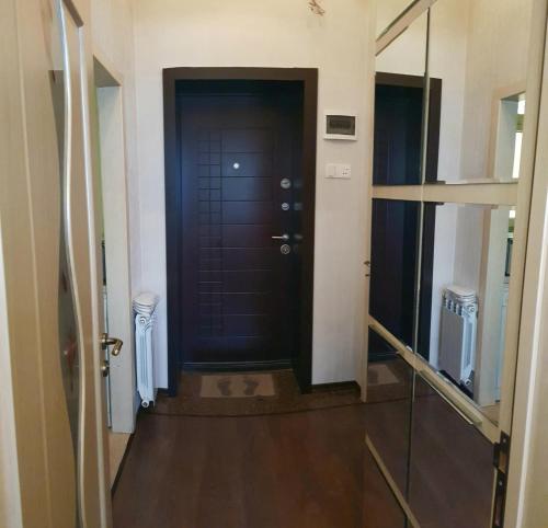 巴库Central Baku Luxury Apartment on Nizami Street的走廊上设有黑色的门,铺有木地板