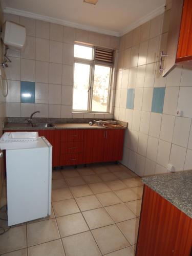 基加利SERENITAS Apartment的厨房配有水槽和冰箱
