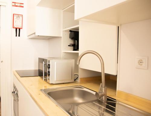 维拉·雷阿尔Apartamentos do Corgo的厨房配有水槽和微波炉