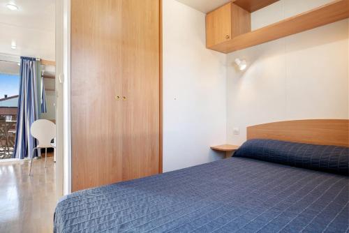 罗切Eloy Playa 3 - Sólo Familias的一间卧室配有一张蓝色的床和木制橱柜。
