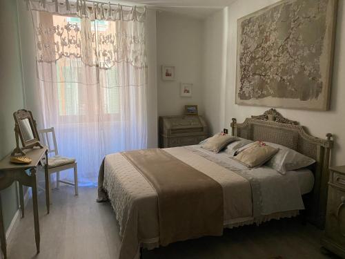 萨罗Violetta Maison, elegante e romantica a Salo’的一间卧室配有一张床、一个梳妆台和一扇窗户。