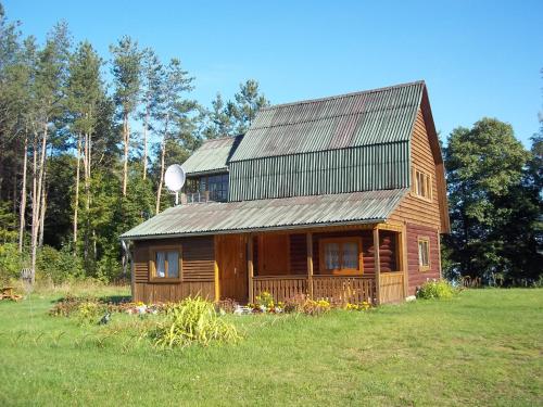 SventePakrasti的田野上带金属屋顶的小木屋