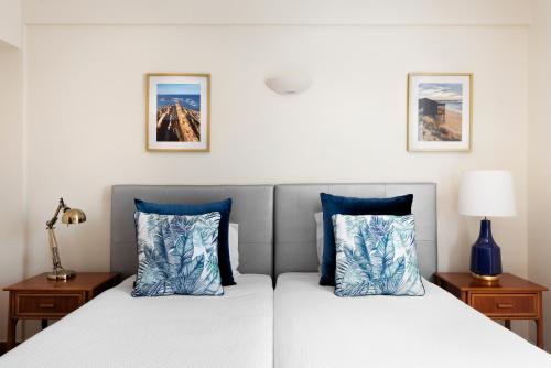米尔芳提斯城The Blue Bamboo Hotel - Duna Parque Group的卧室内的两张床和蓝色枕头