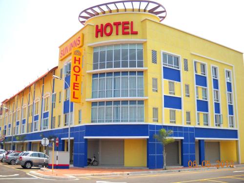 瓜拉雪兰戈瓜拉雪兰戈阳光宾馆的黄色的酒店,上面标有橙色的酒店标志