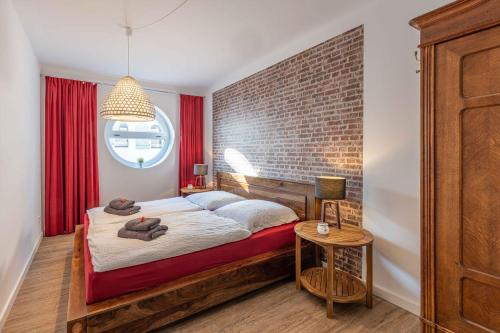 埃肯弗德SEASIDE APARTMENTS - TOWNHOUSE的一间卧室设有一张床和砖墙