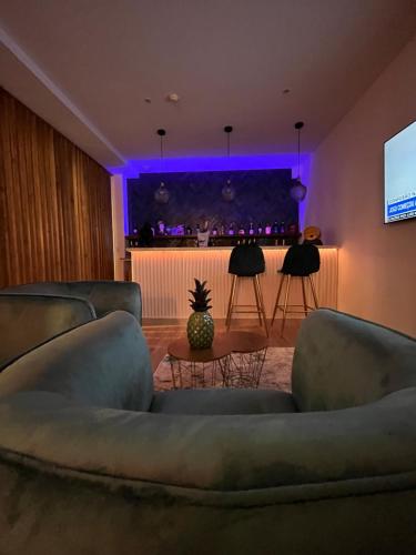 贡多马尔Villarit Porto的带沙发的客厅和带紫色灯的酒吧