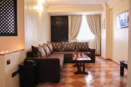 阿加迪尔Hôtel Riad Salam Agadir的客厅配有沙发和桌子