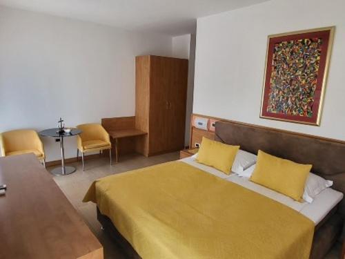 乌马格罗萨住宿加早餐酒店的卧室配有一张床和一张桌子及椅子