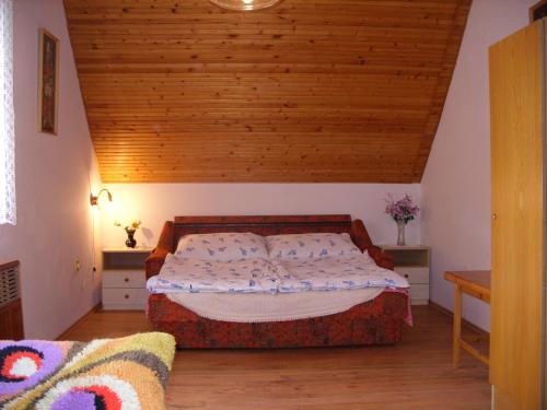 伊高尔Orgona apartman的一间卧室设有一张床和木制天花板