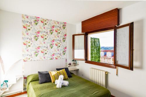莫格罗Apartamento con vistas al mar-Ola del atardecer的一间卧室设有一张绿色的床和一个窗户。