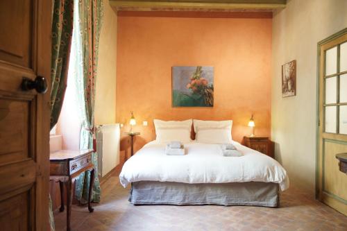 LapaludMaison en Provence的卧室配有一张床,墙上挂有绘画作品