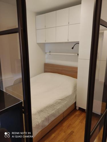 萨格勒布Bosco的一间小卧室,配有白色的橱柜和一张床