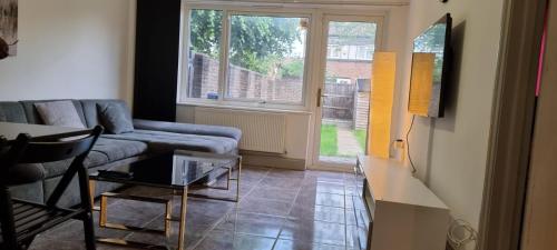 Thamesmead3 bed bedroom house with garden的带沙发、桌子和窗户的客厅