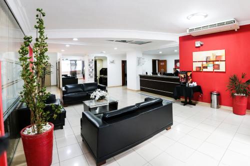 圣若泽杜斯坎普斯Polo Hotel的大堂设有黑色家具和红色的墙壁