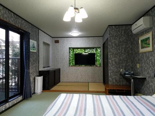 坂井市Bibi Vacation Rental Only 2 groups per day Vacation STAY 1284的卧室配有一张床,墙上配有电视