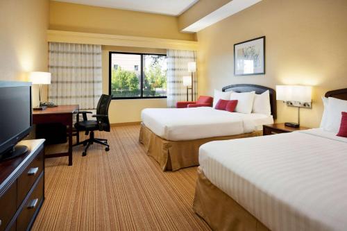 拉斯维加斯拉斯维加斯萨姆林万怡酒店的酒店客房设有两张床、一张桌子和一台电视。